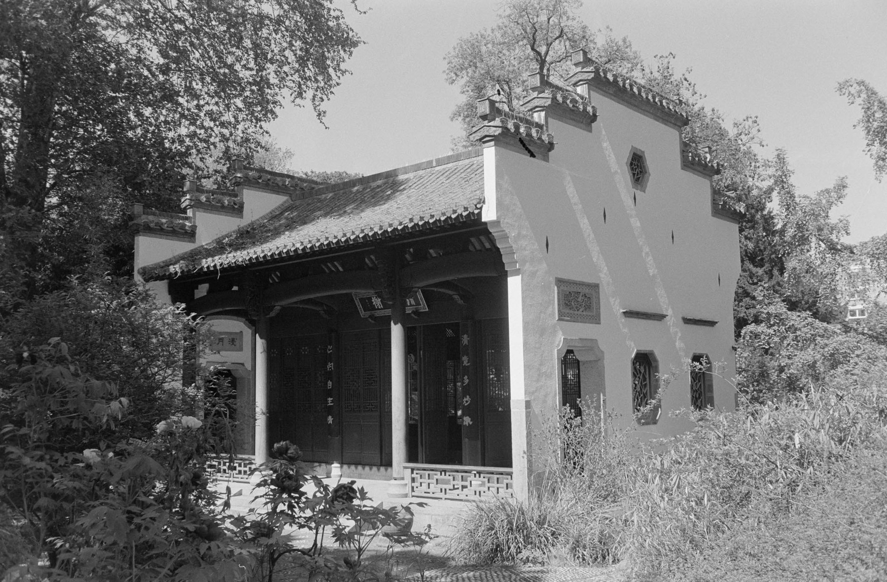 A traditional Chinese-style building is surrounded by trees and greenery.